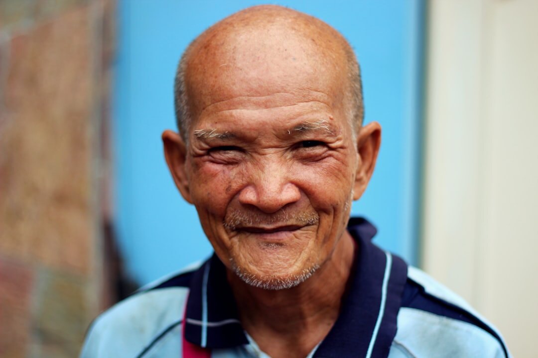 Smiling elderly man with grey hair looking at the camera