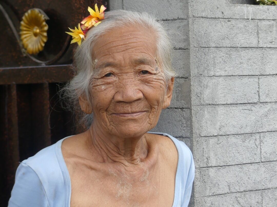 Smiling elderly woman with silver hair looking at the camera
